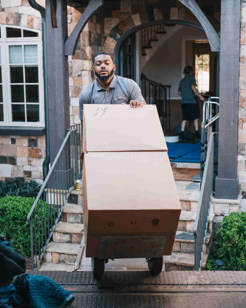 Family unpacking moving boxes off a removal truck