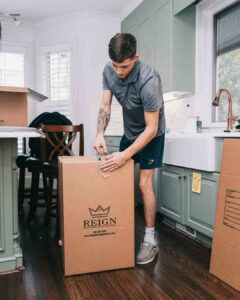 Worker using a tape dispenser on a packing box