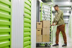 Man wheeling boxes into storage unit