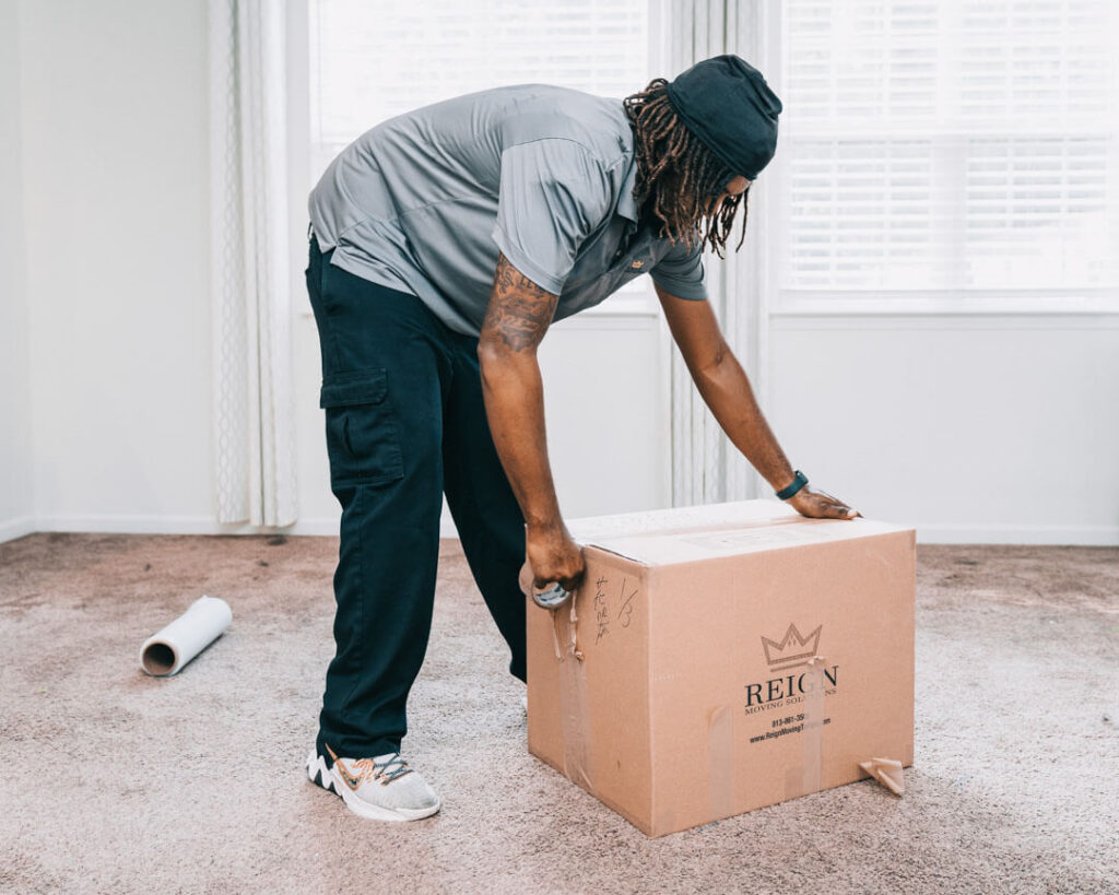 A man carefully boxing items for a move