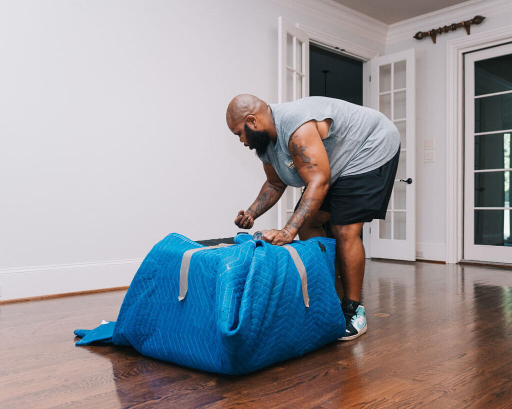 A man carefully wrapping items for a move