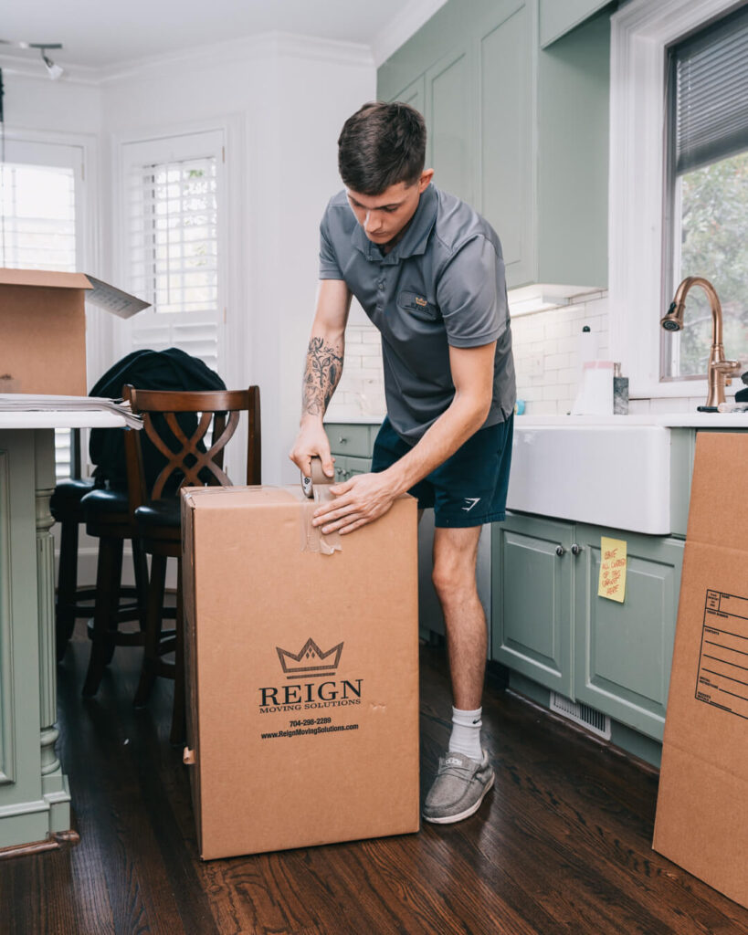 A man packing a cardboard box for a move